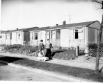 A family outside one of the prefabs